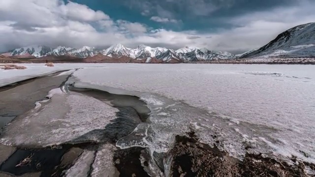 4K60P延时摄影冰湖雪地上风起云涌飘向雪山视频视频素材