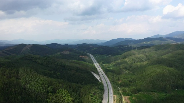 蓝天白云下穿过群山的高速公路视频素材