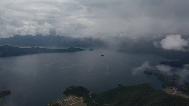 从格姆女神山上空的云雾中飞过俯瞰泸沽湖风光视频素材