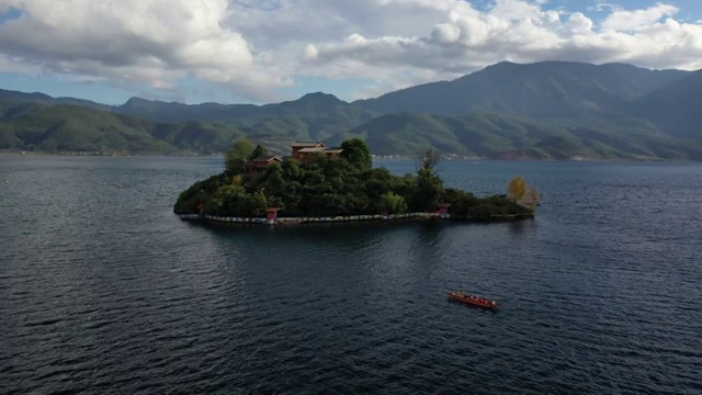 空中俯瞰泸沽湖王妃岛四周船只来来往往的景观视频素材