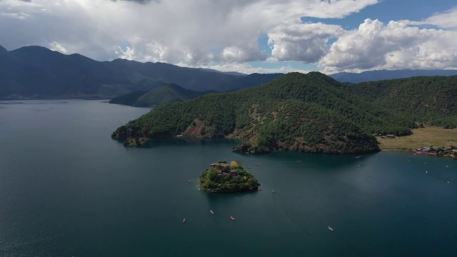 空中俯瞰泸沽湖王妃岛四周船只来来往往的景观视频素材