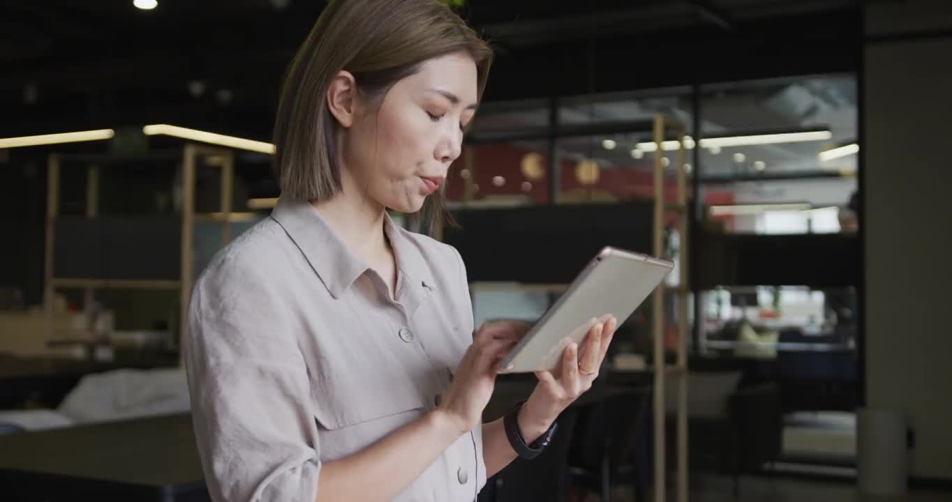 亚洲女商人在现代办公室里使用数字平板电脑视频素材