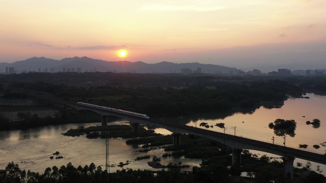 夕阳下小河上铁路桥行驶的高速列车视频素材