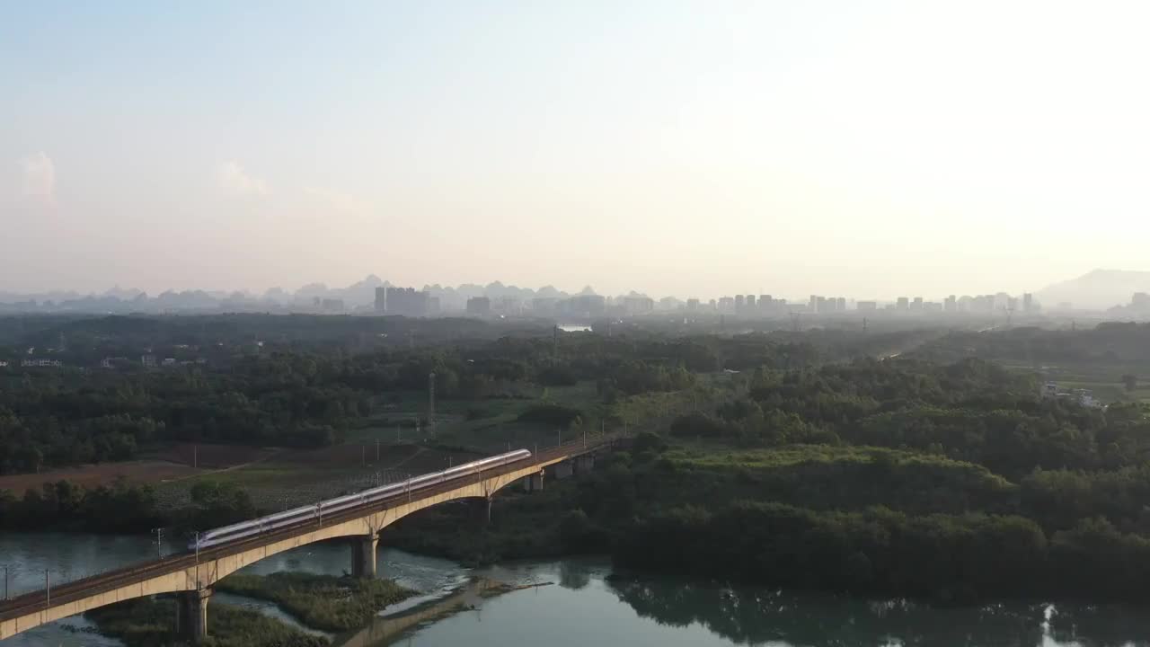 夕阳下小河上铁路桥行驶的高速列车视频素材