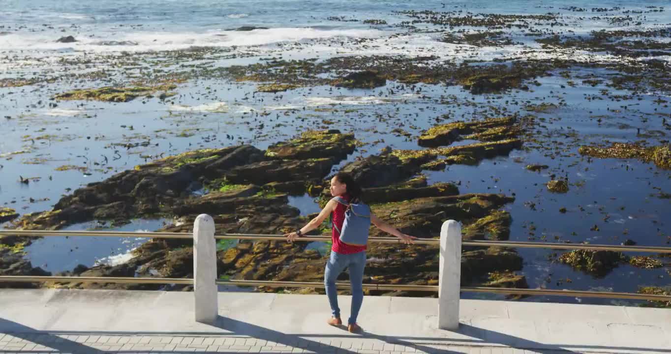 一位非裔美国妇女站在海边的散步道上视频素材