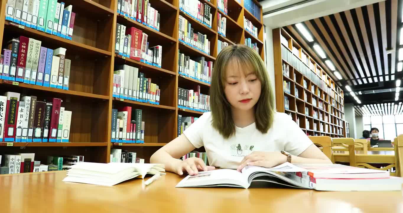 4K拍摄一个图书馆看书的女人视频素材