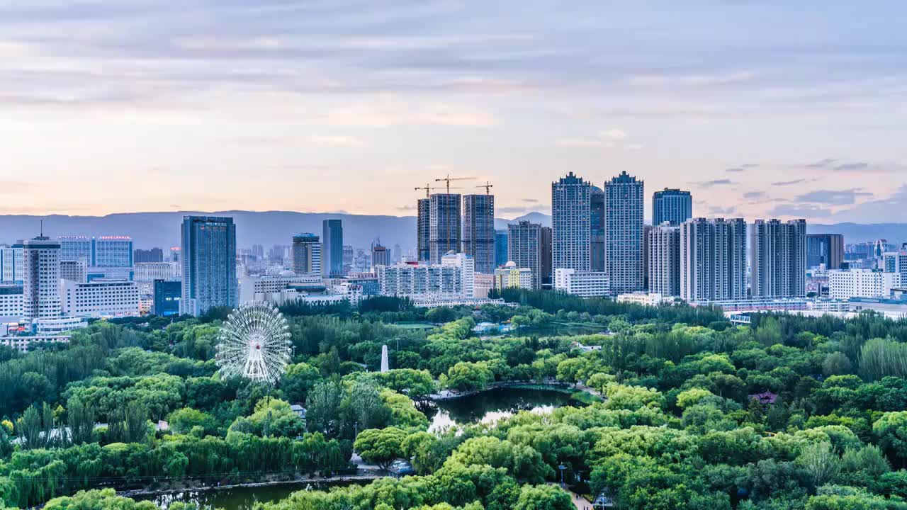 中国内蒙古呼和浩特青城公园摩天轮和城市天际线夜景视频素材