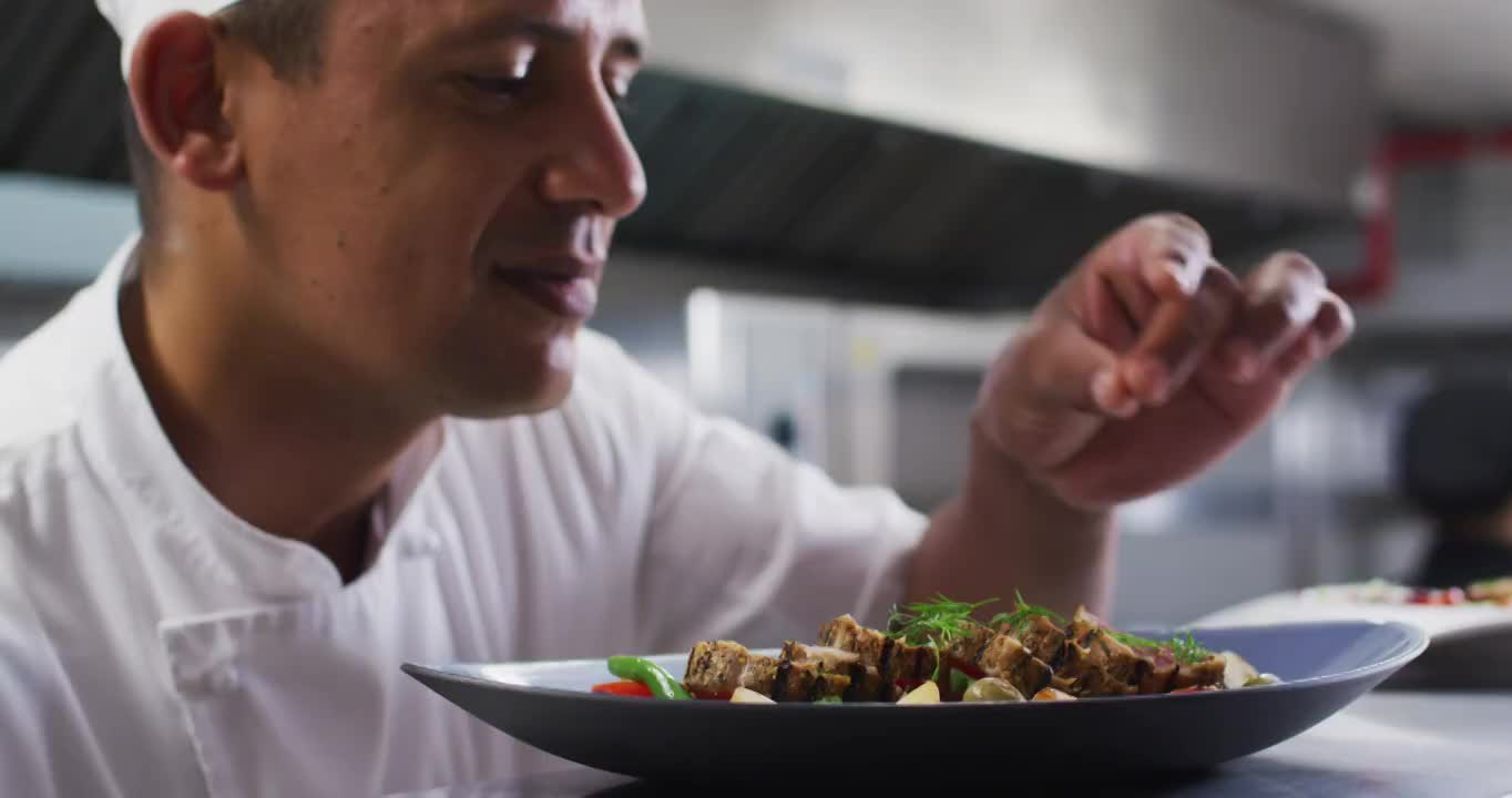 白种男厨师在餐厅厨房里微笑着装饰菜肴视频素材