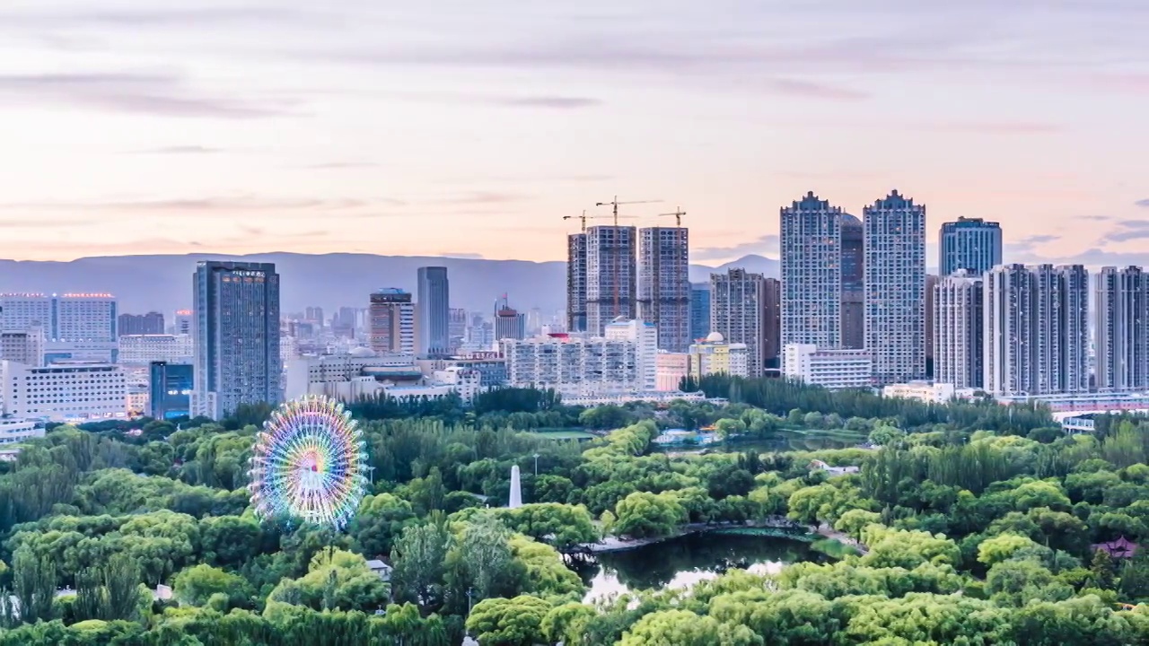 中国内蒙古呼和浩特青城公园摩天轮和城市天际线日转夜延时摄影视频素材