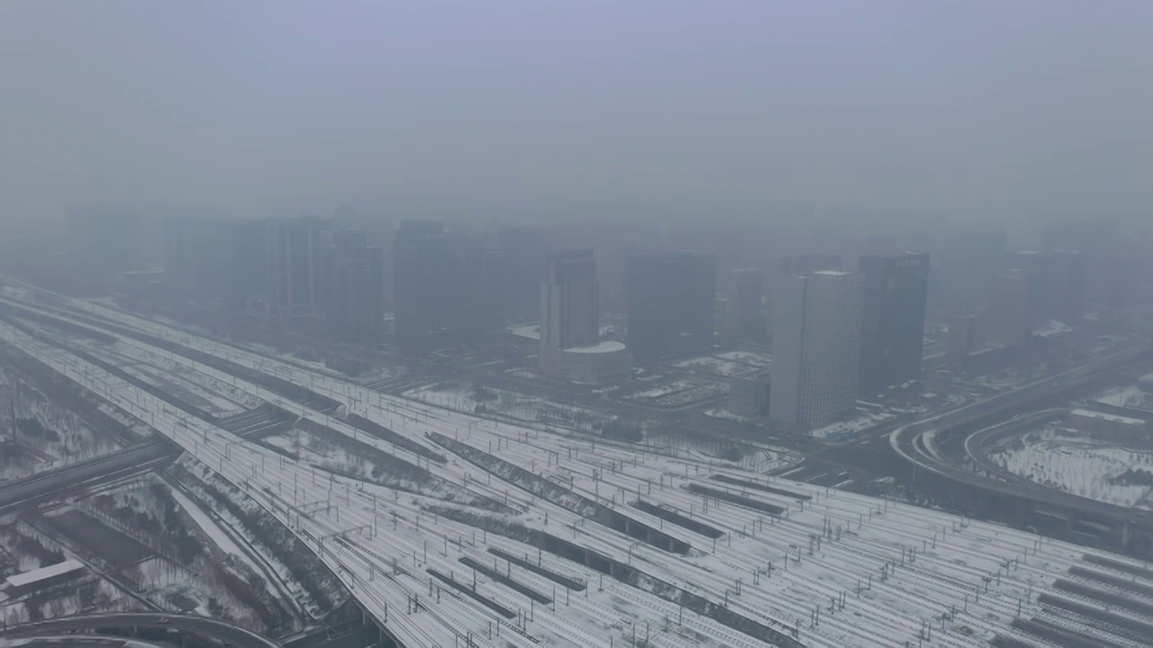 河南郑州高铁站郑州东站和谐号高铁进出站冬季雪景户外航拍视频素材