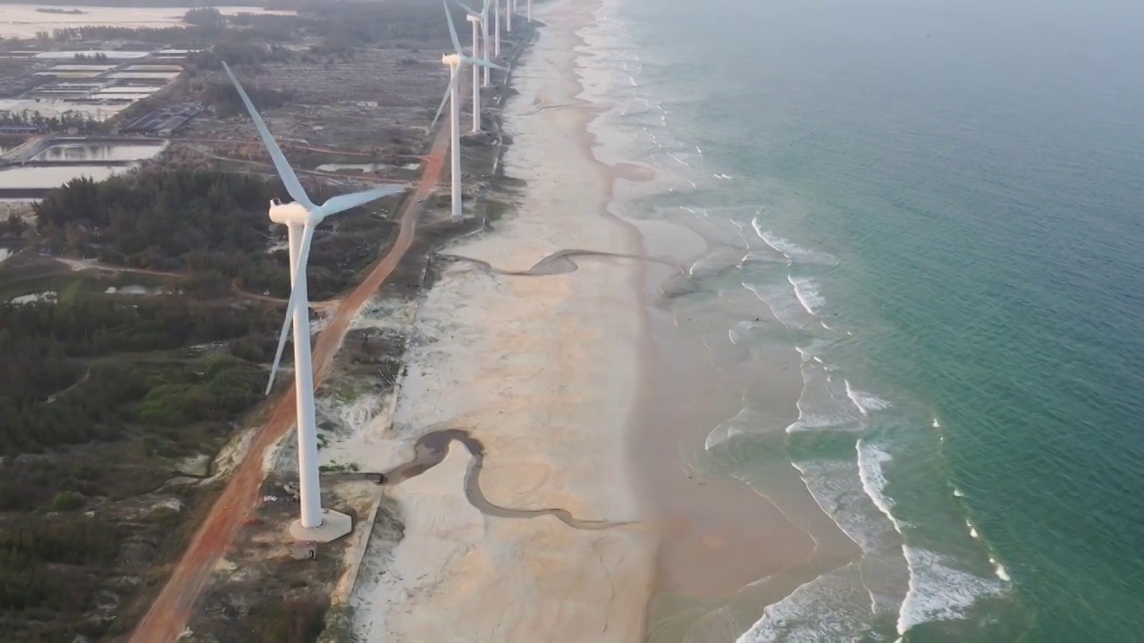 航拍海南文昌海岸沙滩风力发电机少女海滩行走视频素材