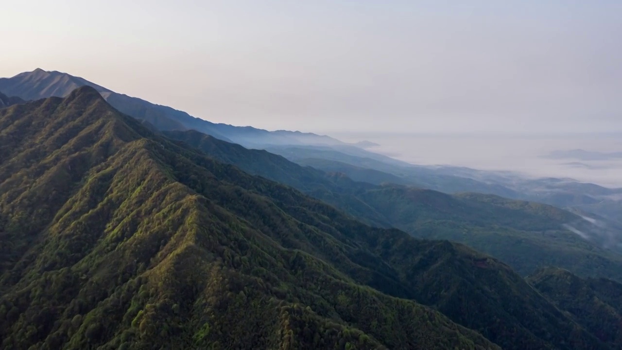 航拍日出时分被阳光照亮的山峰和云海视频下载