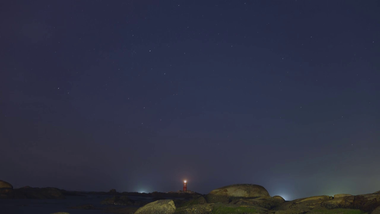 星空下的海岛灯塔，灯塔亮灯指引着航行的人们视频素材