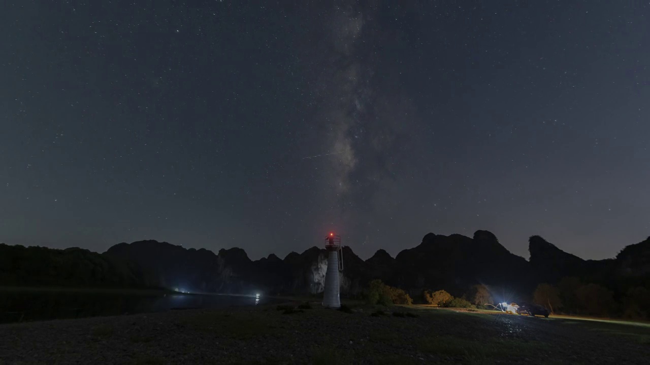 深夜桂林漓江河滩上的露营者和灯塔上的星空银河视频素材