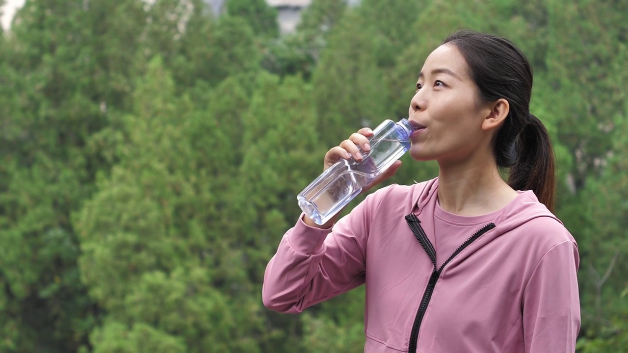 亚洲中国人女性在户外森林大自然喝水饮用水视频素材