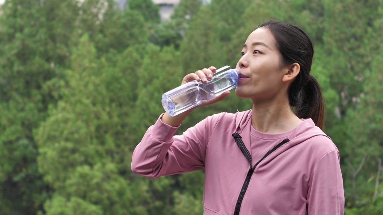 亚洲中国人女性在户外森林大自然喝水饮用水视频素材