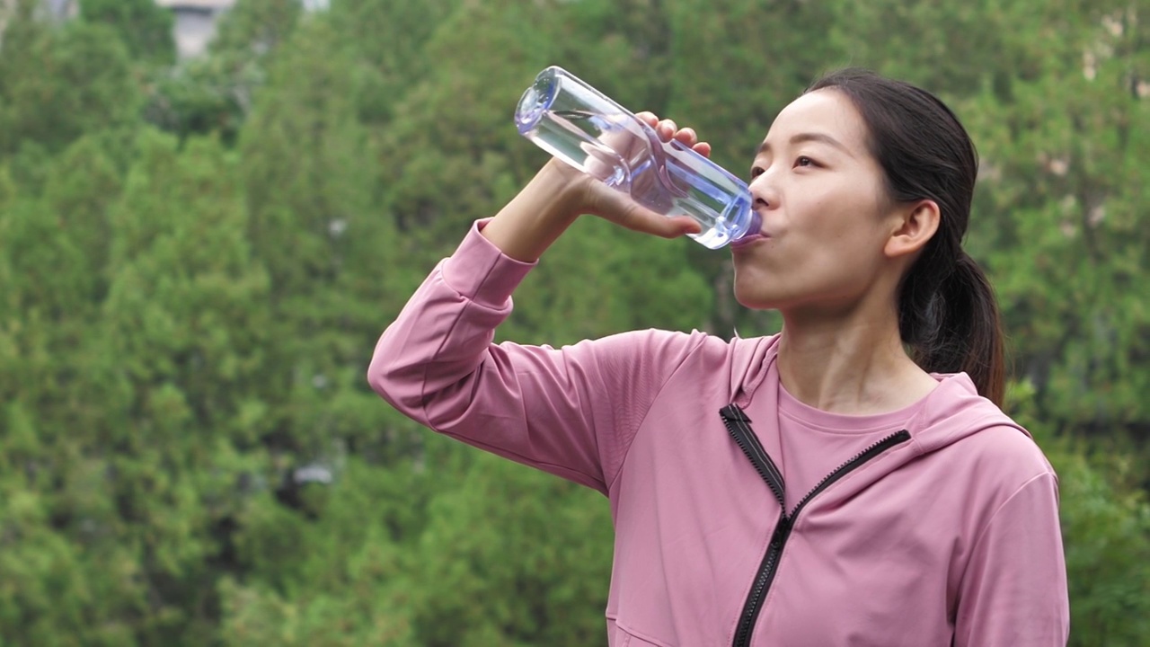 亚洲中国人女性在户外森林大自然喝水饮用水视频素材