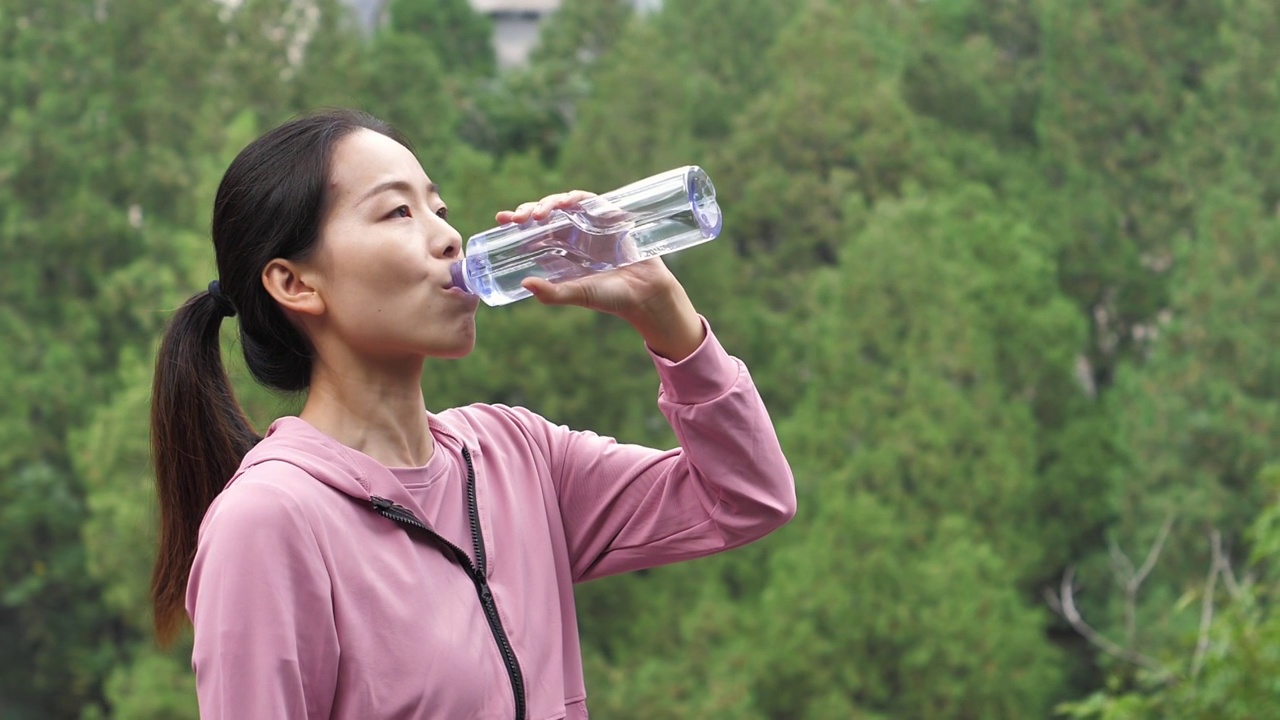 亚洲中国人女性在户外森林大自然喝水饮用水视频素材