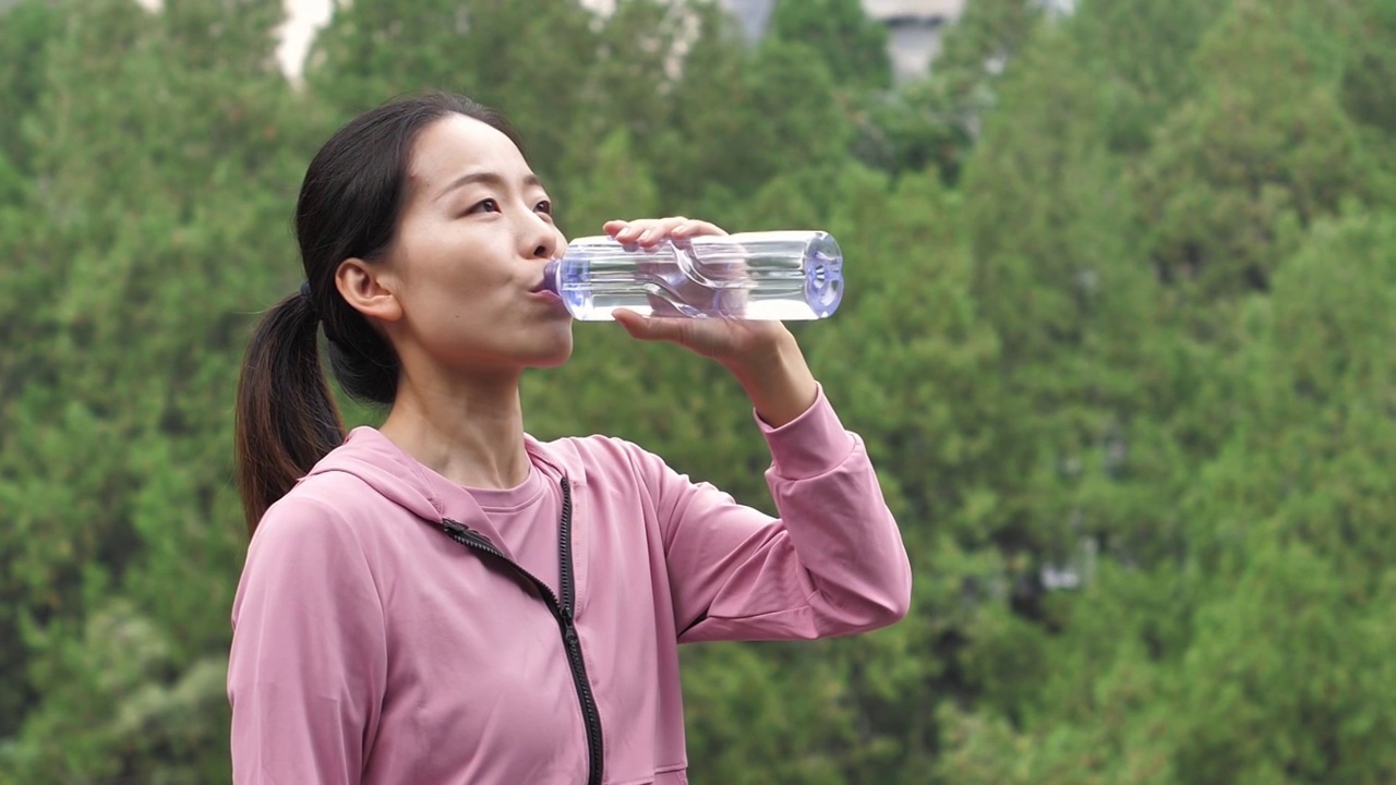 亚洲中国人女性在户外森林大自然喝水饮用水视频素材