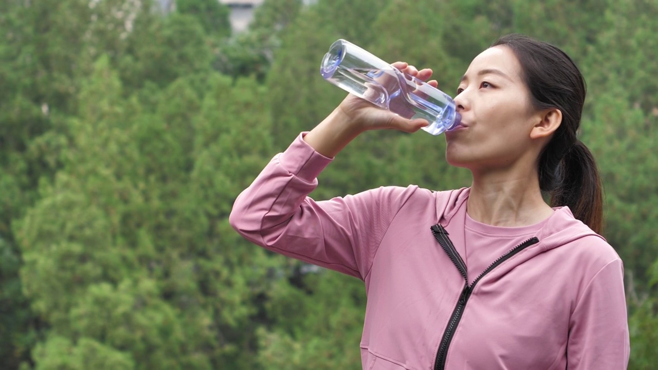 亚洲中国人女性在户外森林大自然喝水饮用水视频素材