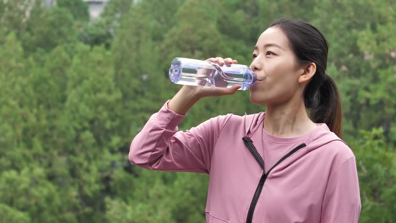 亚洲中国人女性在户外森林大自然喝水饮用水视频素材