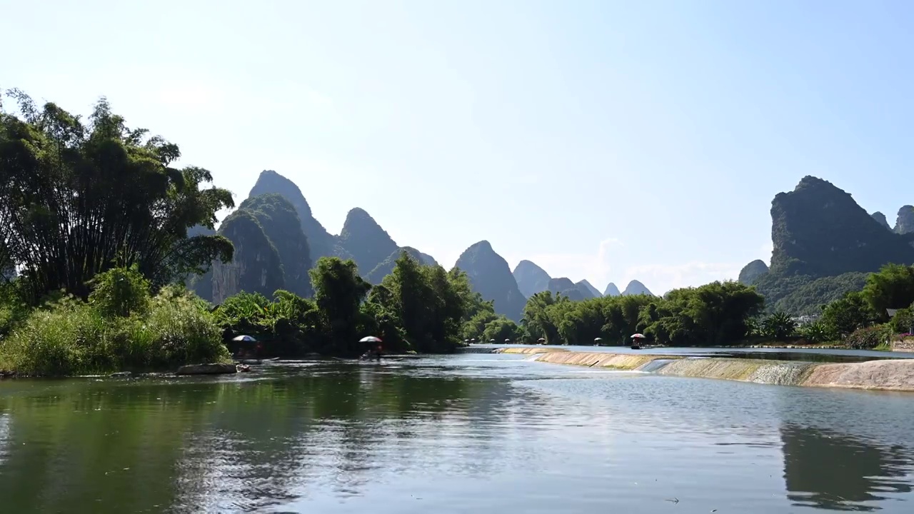 蓝天白云下桂林阳朔遇龙河上漂流的竹筏视频素材