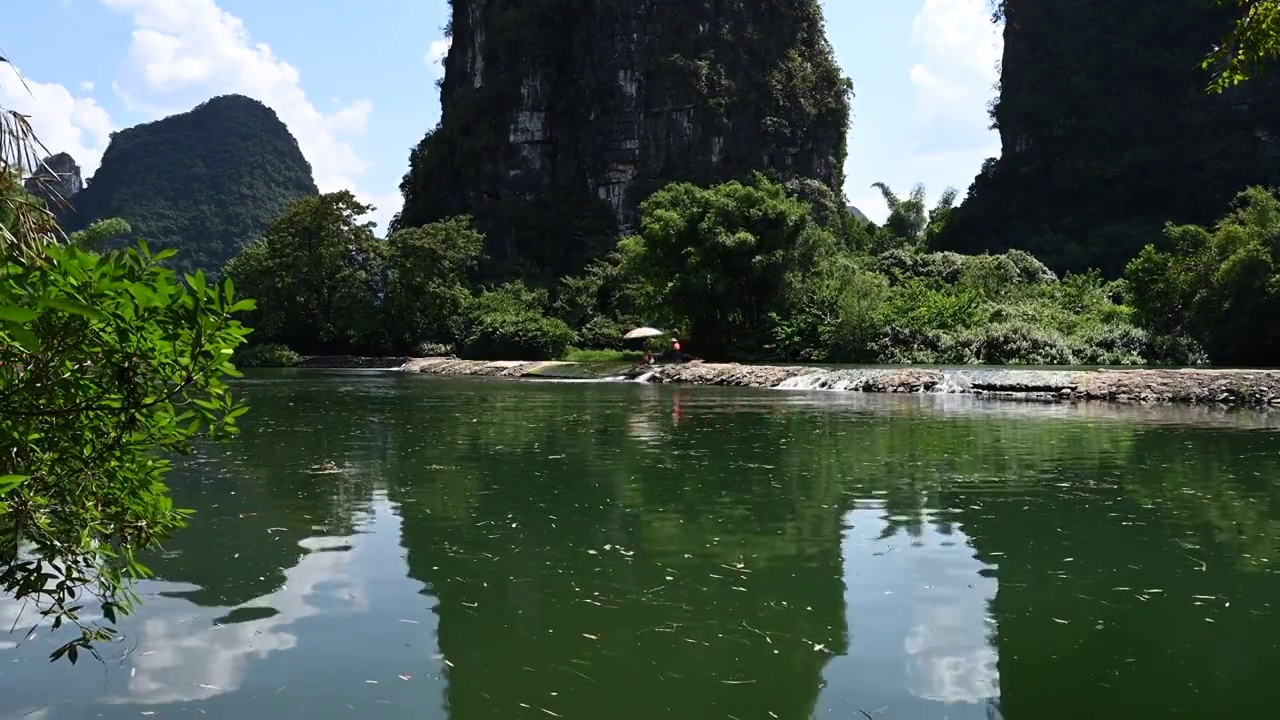 蓝天白云下桂林阳朔遇龙河上漂流的竹筏视频素材