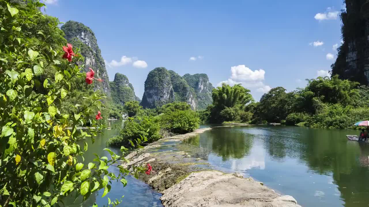 蓝天白云下桂林阳朔遇龙河上漂流的竹筏视频素材