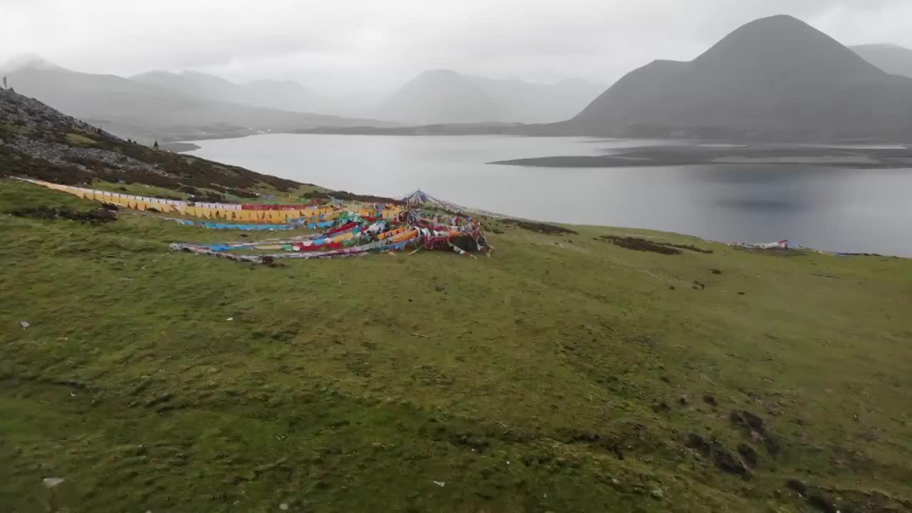 航拍西藏“财神湖”思金拉错，无人机从远处低空飞行越过经幡视频下载