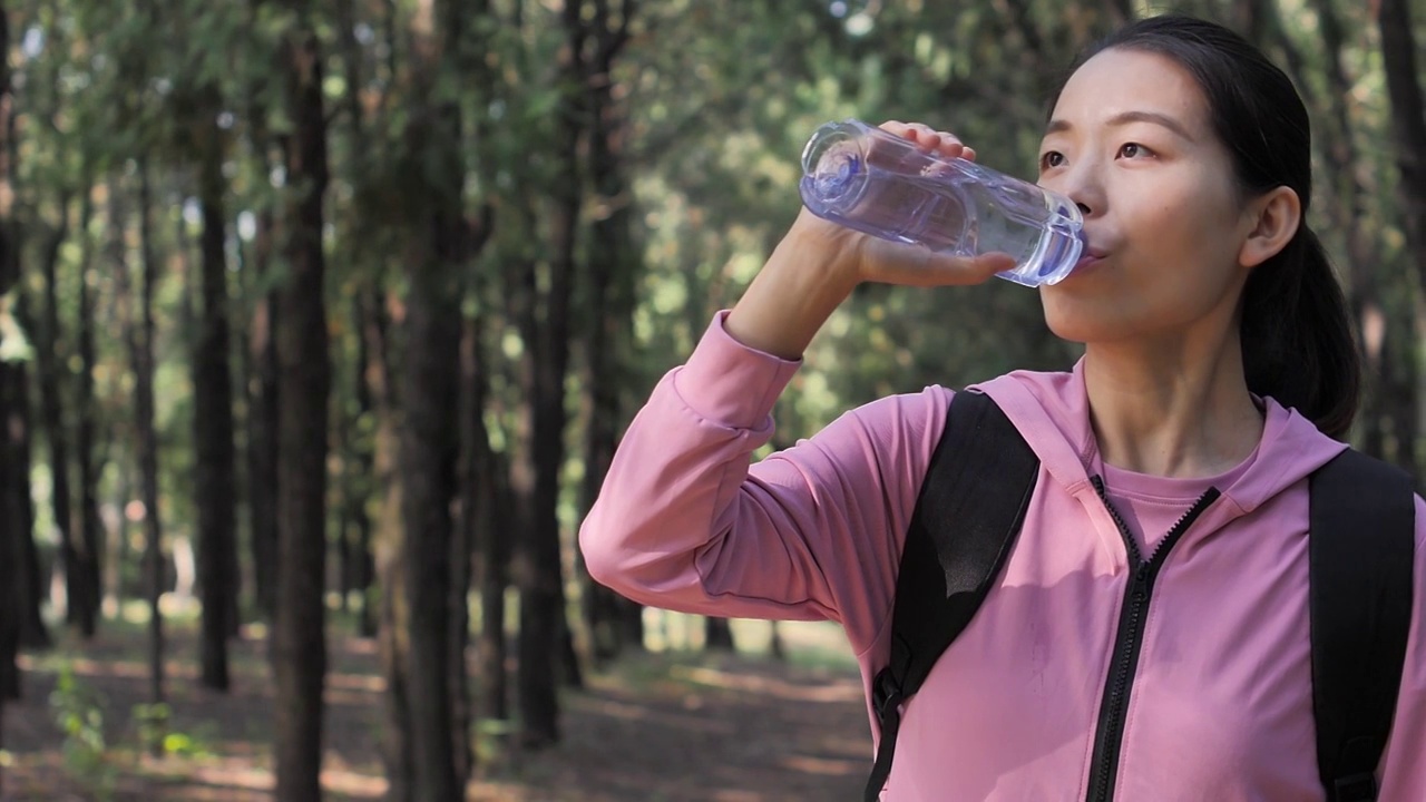 亚洲中国人女性在户外森林大自然喝水饮用水视频素材