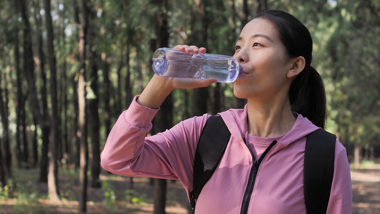 亚洲中国人女性在户外森林大自然喝水饮用水视频素材