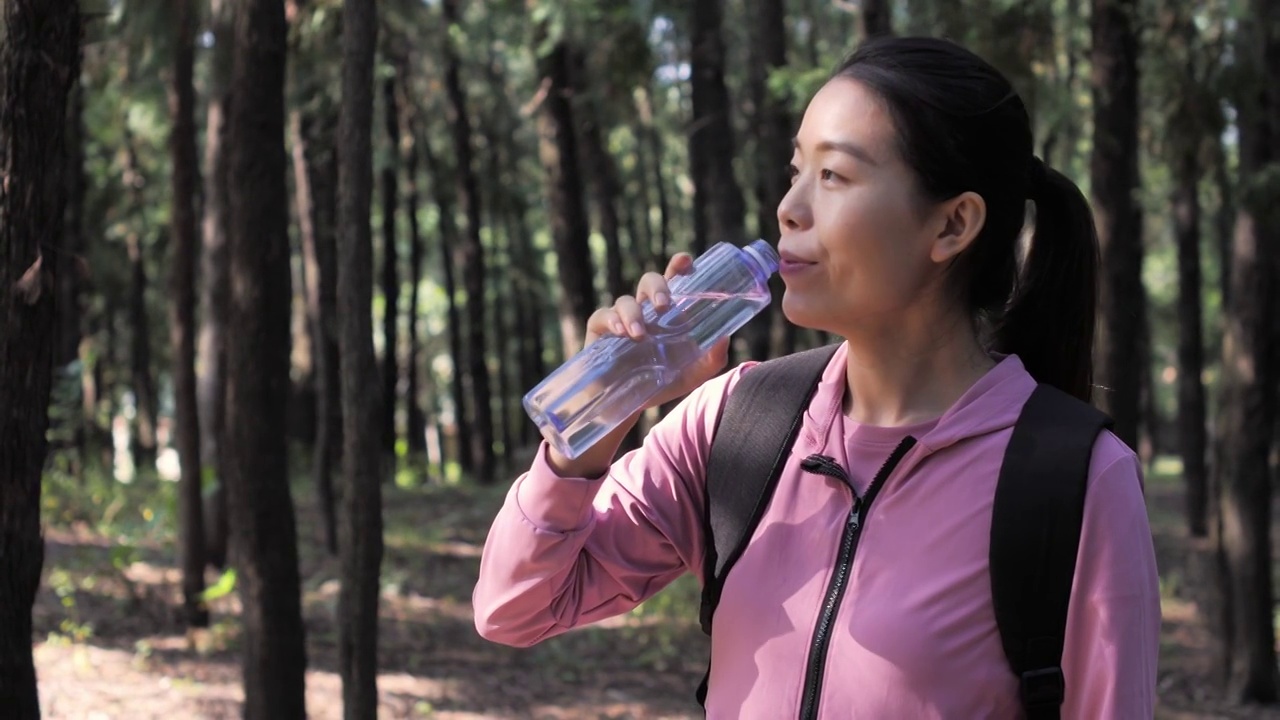 亚洲中国人女性在户外森林大自然喝水饮用水视频素材