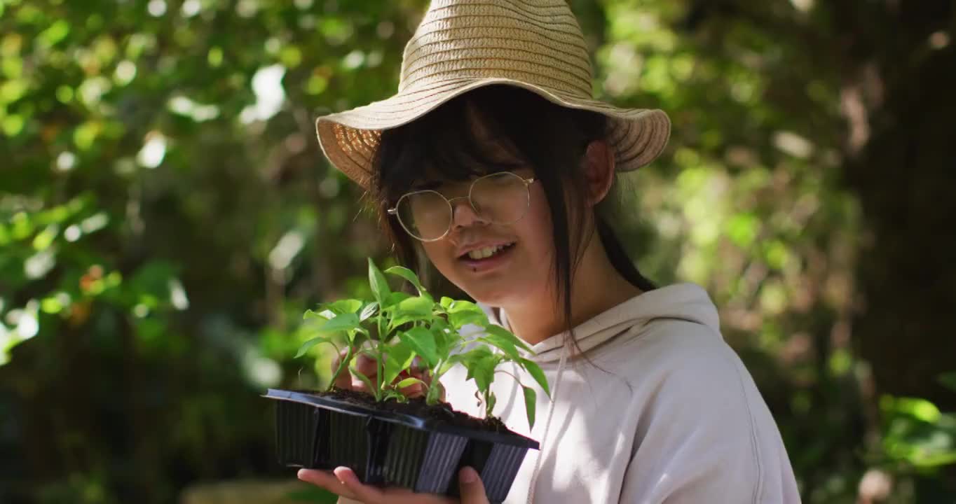 亚洲女孩在阳光明媚的日子里园艺和微笑视频素材