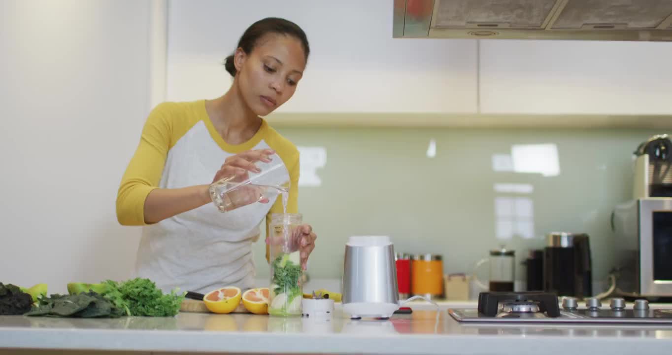 混合种族妇女准备健康的饮料在厨房视频素材