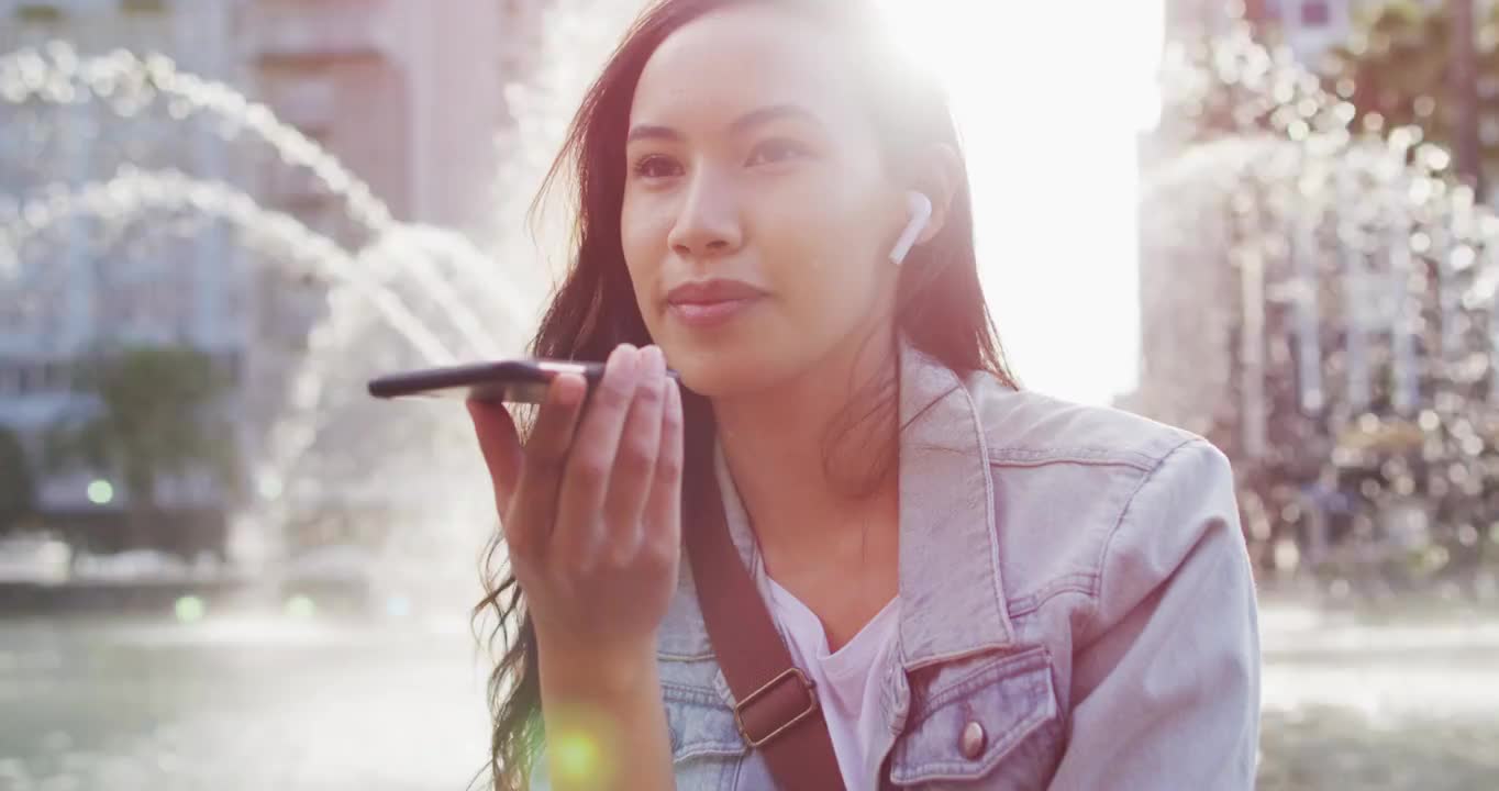 亚洲女性戴着耳机在电话里聊天视频素材