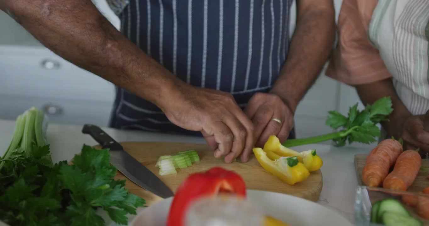 快乐的非裔美国老夫妇一起做饭的中段视频素材