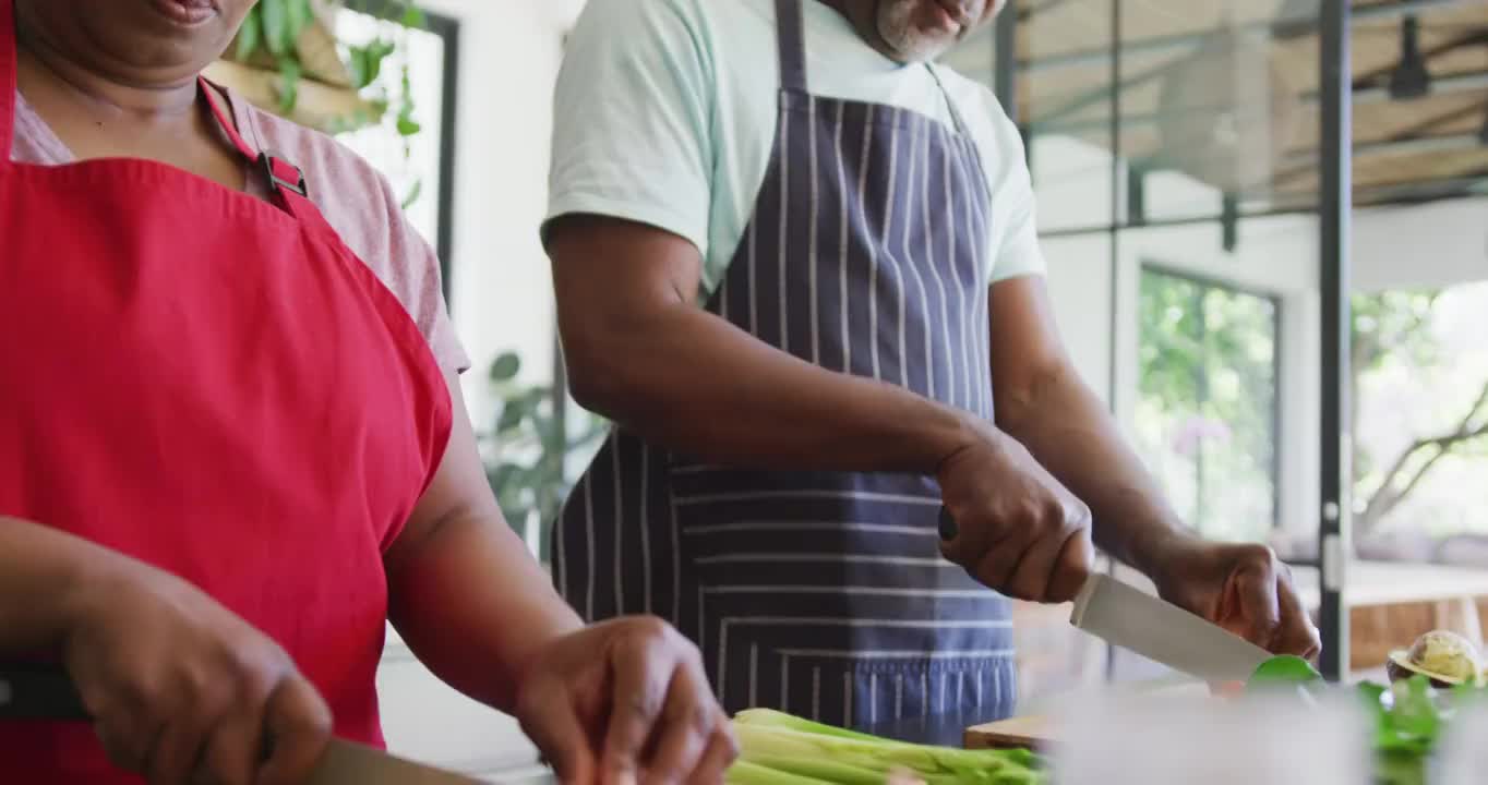 快乐的非裔美国老夫妇在厨房一起做饭视频素材