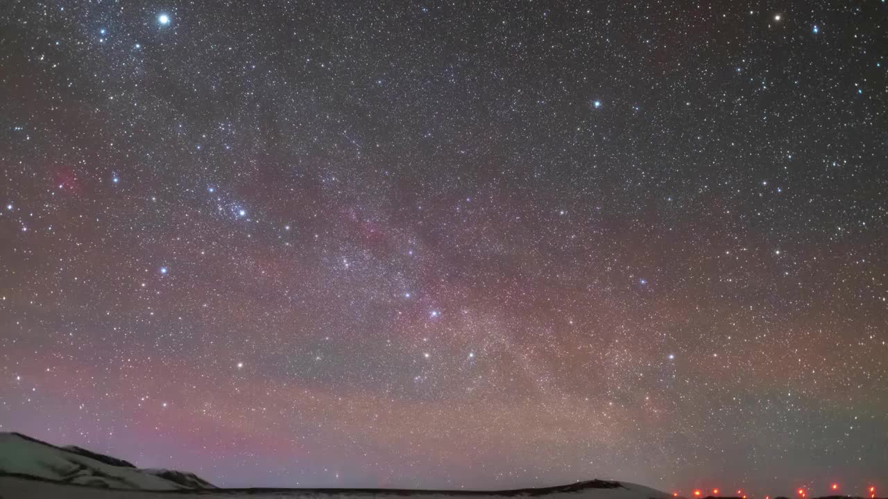 星空延时：繁星下地球自转与彩色气辉涟漪视频素材