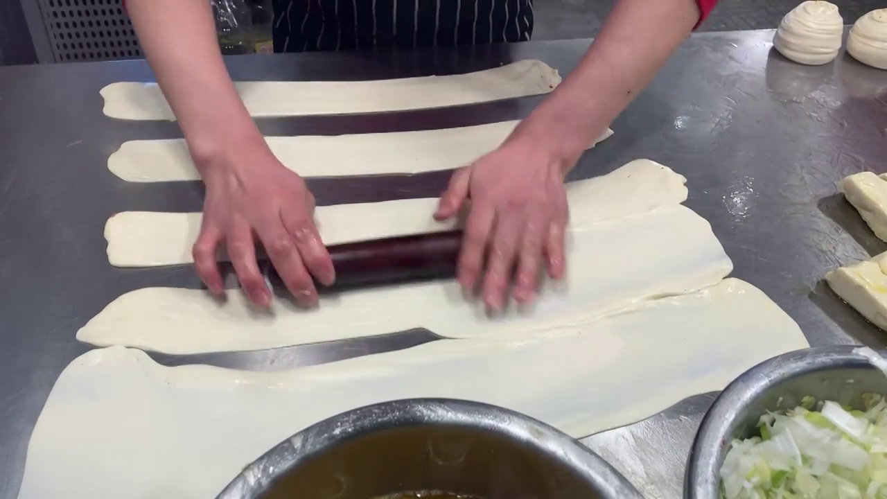 烹饪美食：牛肉饼的制作，用擀面棒把面皮擀得更薄视频素材