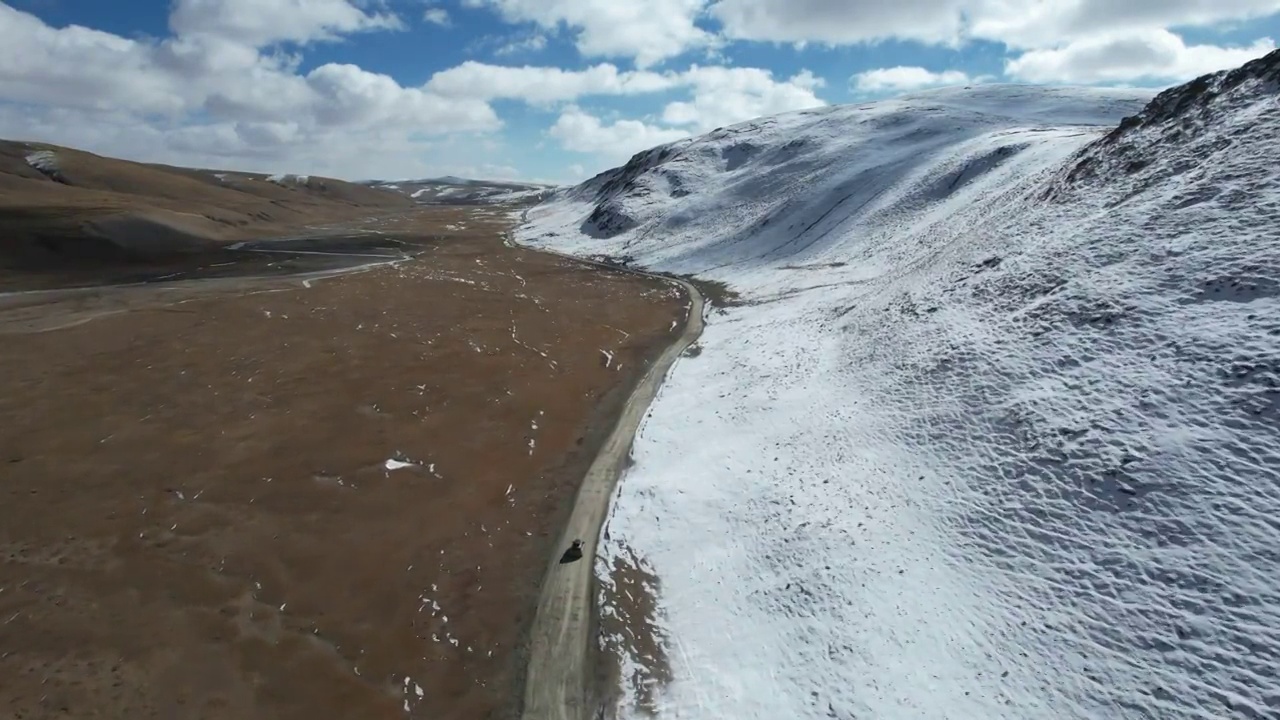 青海果洛州玛多县三江源国家公园雪原公路自驾游旅行航拍视角视频素材