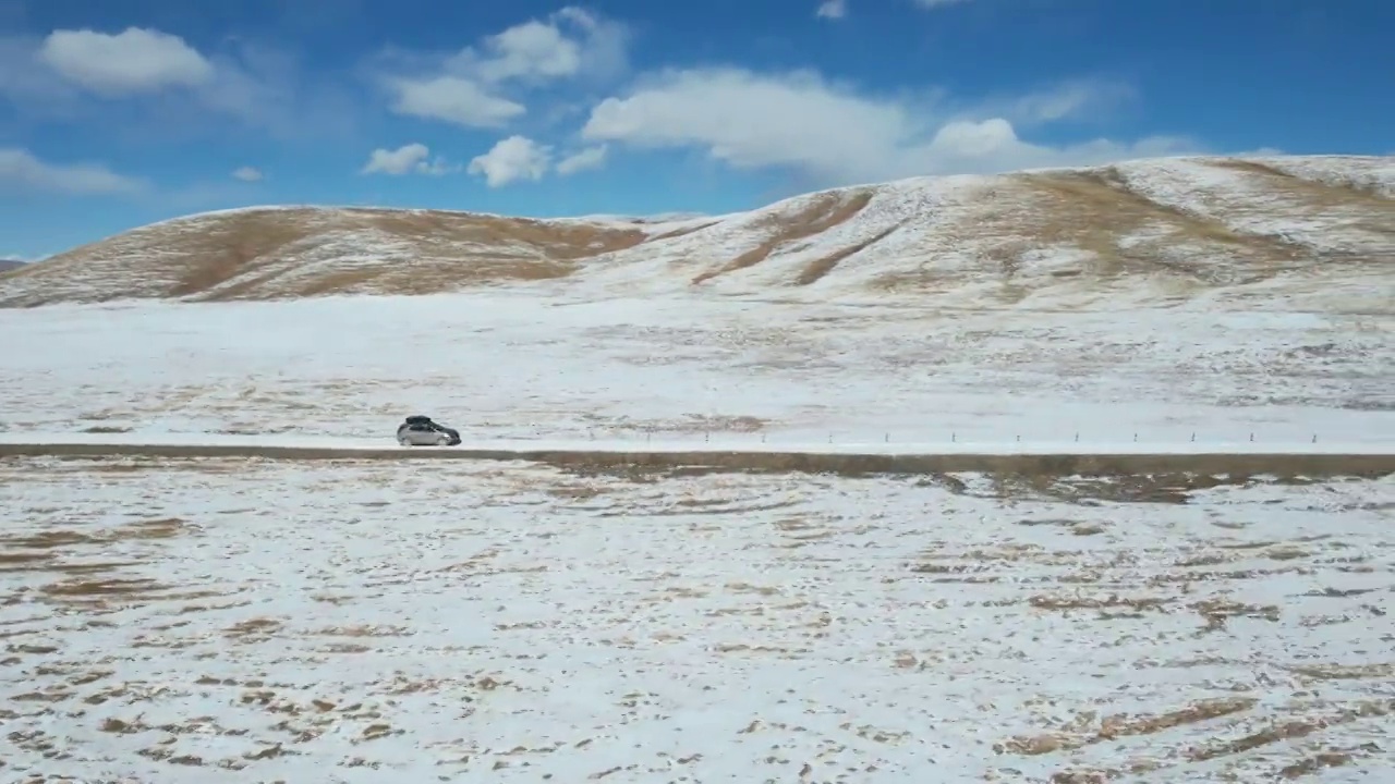 青海果洛州玛多县三江源国家公园雪原公路自驾游旅行航拍视角视频素材