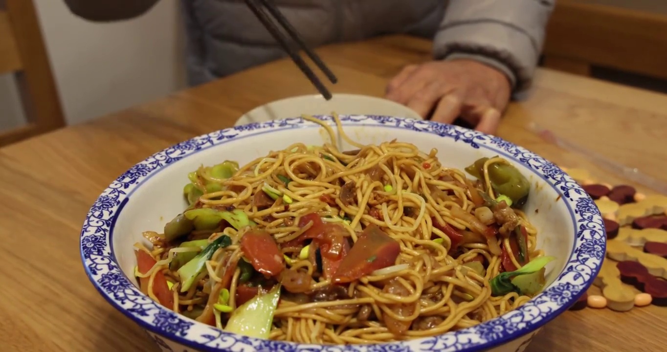 美食：把什锦蔬菜炒面挑进碗里分餐食用视频素材