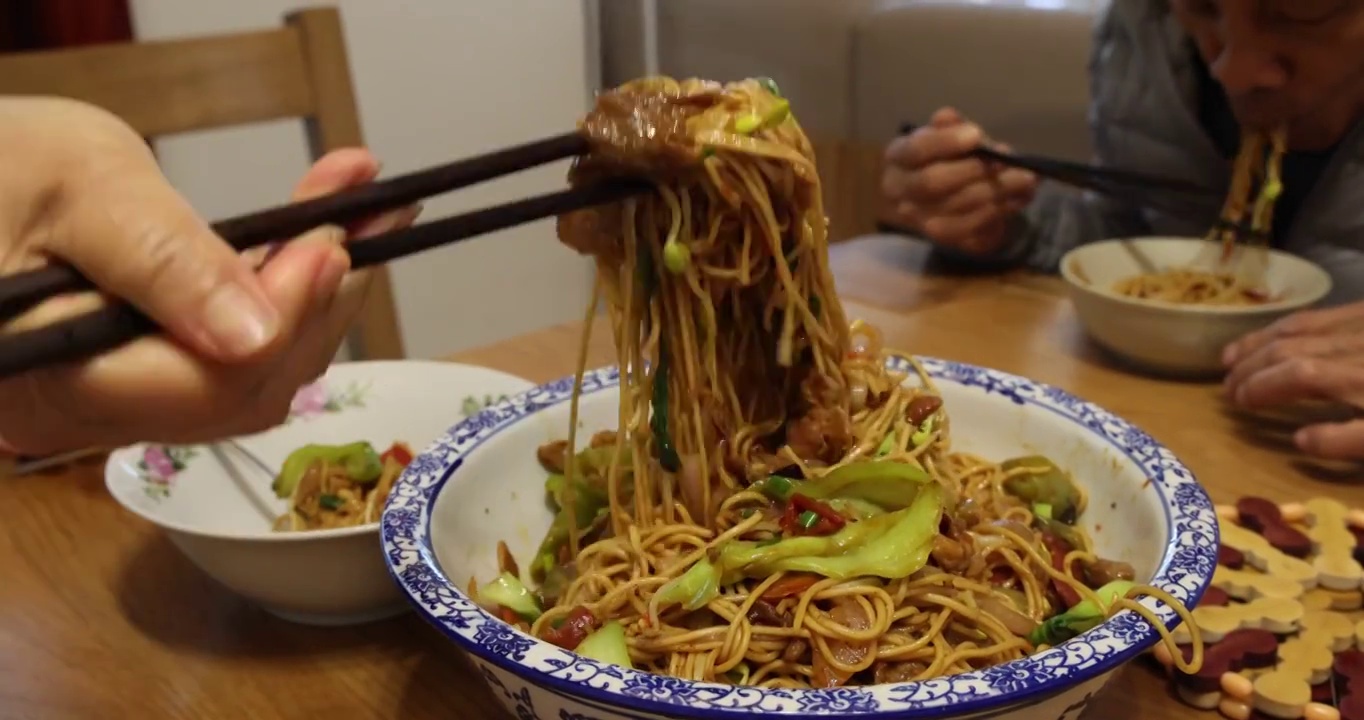 美食：把什锦蔬菜炒面挑进碗里分餐食用视频素材