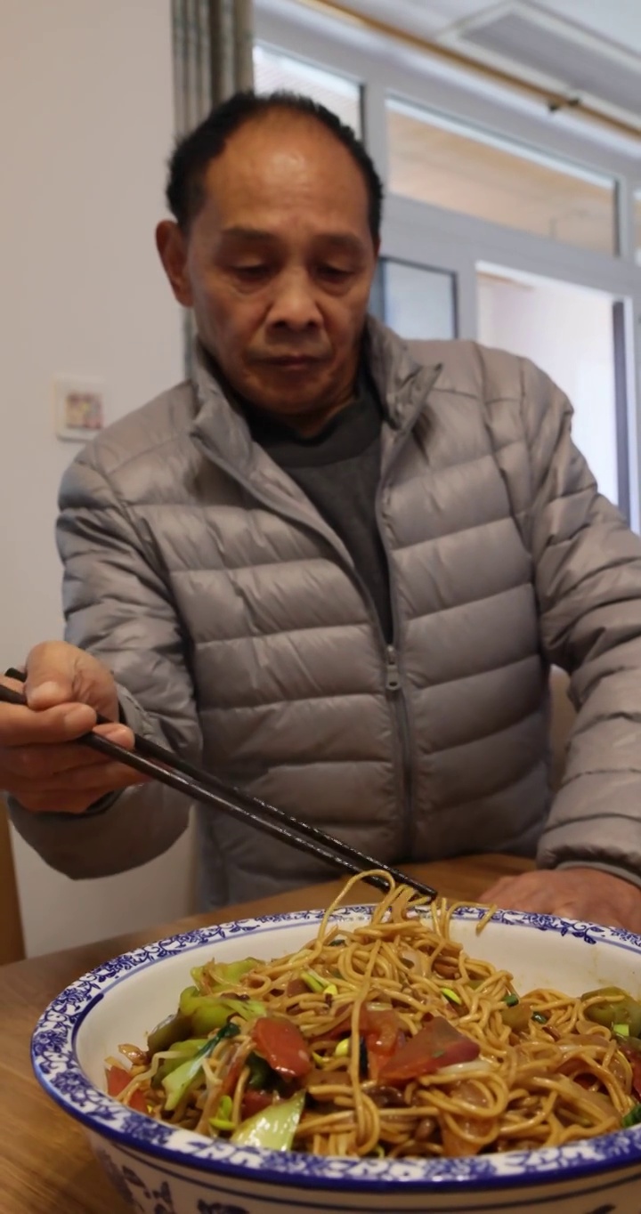 美食人像：男人从盘子里挑出什锦蔬菜炒面分餐食用视频素材