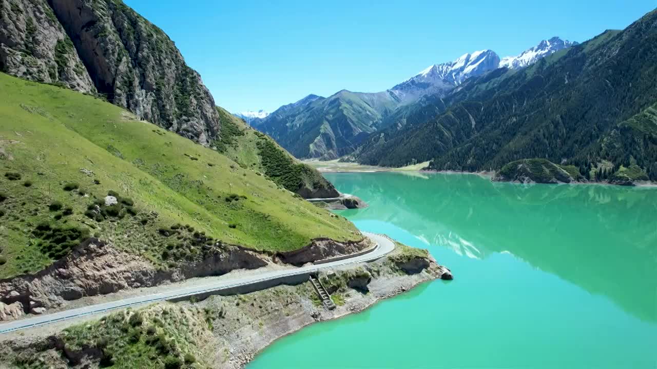 新疆伊犁独库公路大龙池，无人机航拍碧绿湖水被雪山环抱，倒影如画绝美自然风光视频素材