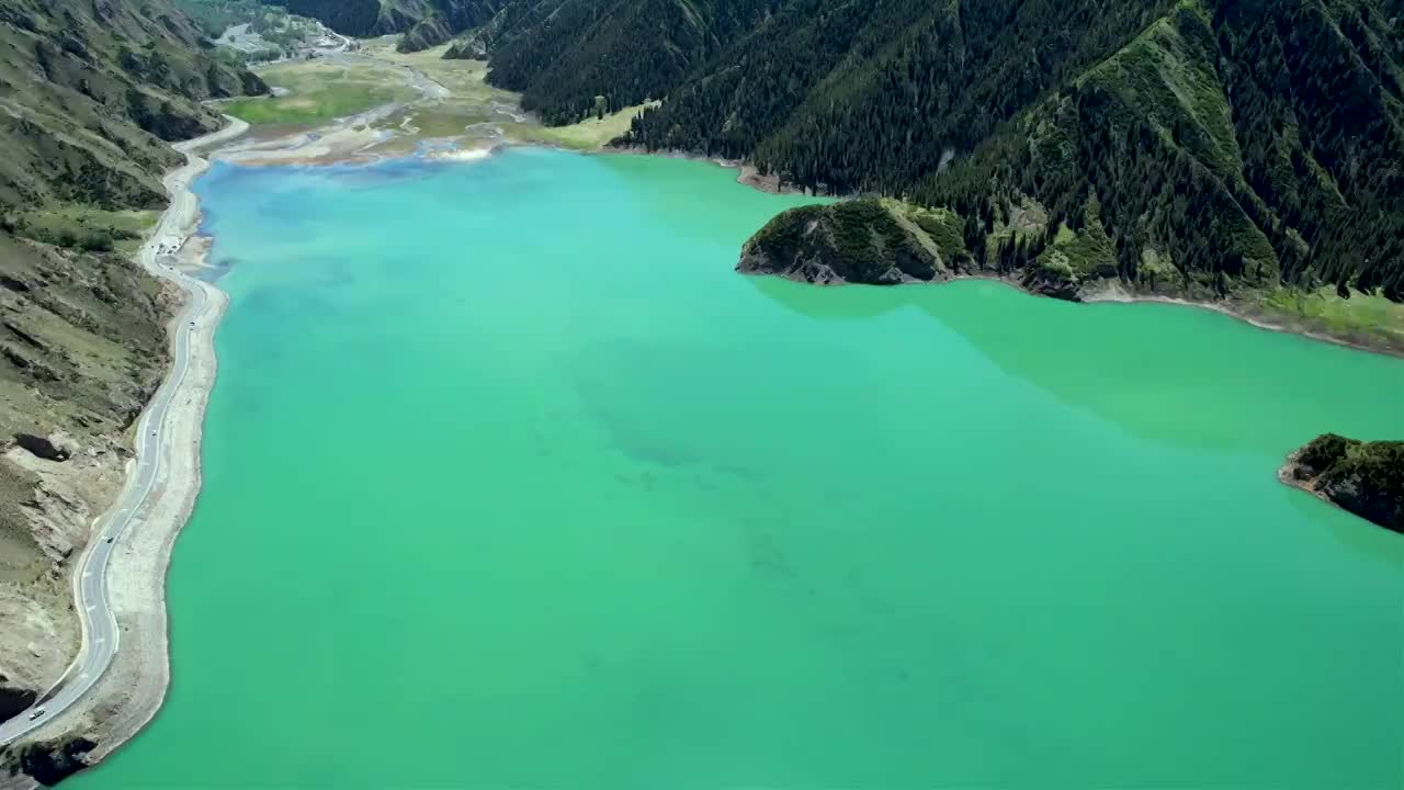 新疆伊犁独库公路大龙池，无人机航拍碧绿湖水被雪山环抱，倒影如画绝美自然风光视频素材