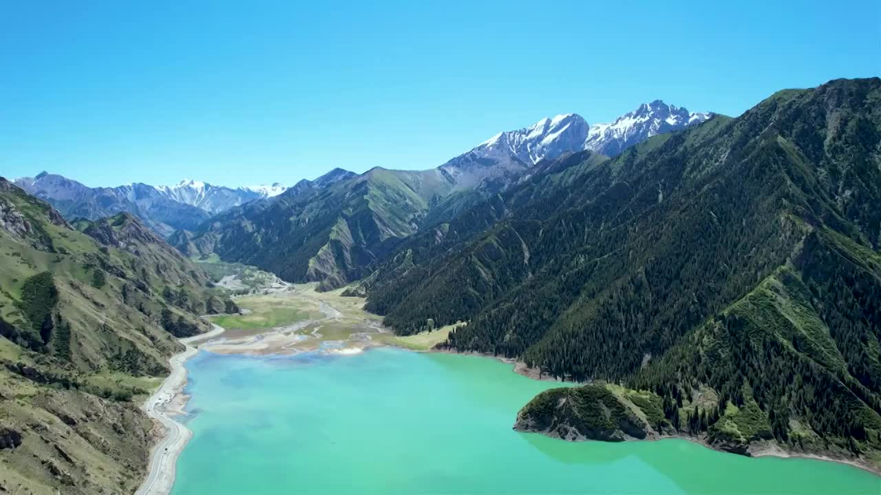 新疆伊犁独库公路大龙池，无人机航拍碧绿湖水被雪山环抱，倒影如画绝美自然风光视频素材