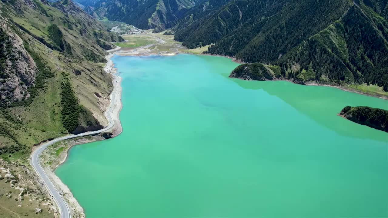 新疆伊犁独库公路大龙池，无人机航拍碧绿湖水被雪山环抱，倒影如画绝美自然风光视频素材