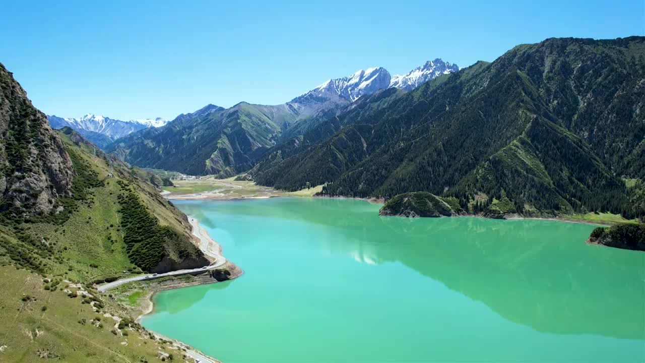 新疆伊犁独库公路大龙池，无人机航拍碧绿湖水被雪山环抱，倒影如画绝美自然风光视频素材