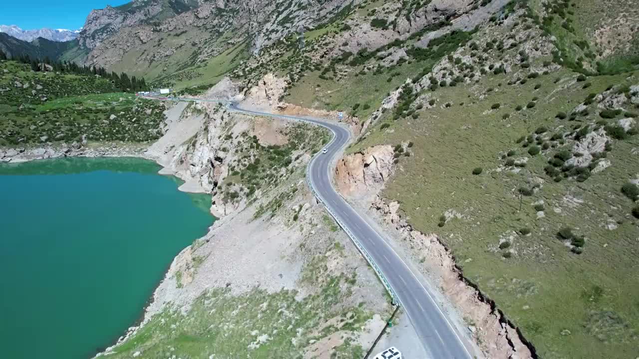 新疆伊犁独库公路大龙池，无人机航拍碧绿湖水被雪山环抱，倒影如画绝美自然风光视频素材